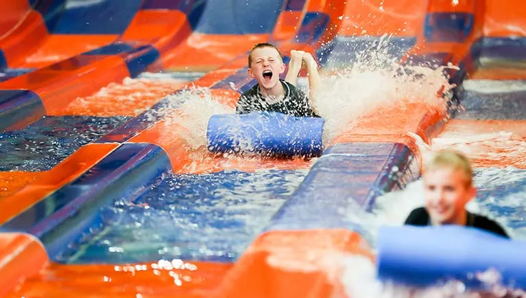 A boy smiles at the end of his slide