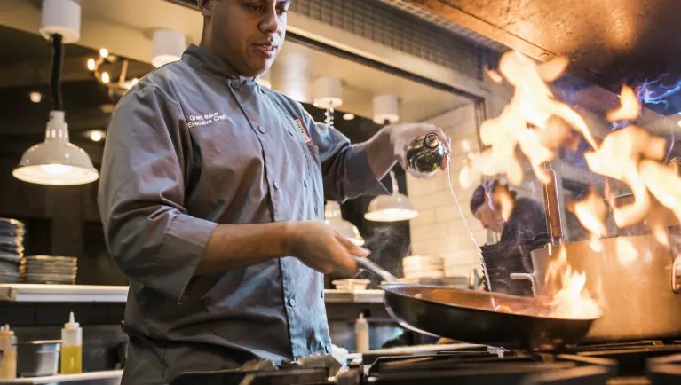 A chef preparing delicious food at Barnwood at Great Wolf Lodge indoor water park and resort.