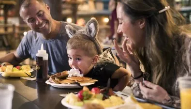 A family enjoying a meal at Camp Critter Bar & Grille at Great Wolf Lodge indoor water park and resort..