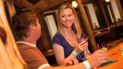 A couple enjoys drinks at The Outpost bar at Great Wolf Lodge indoor water park and resort.