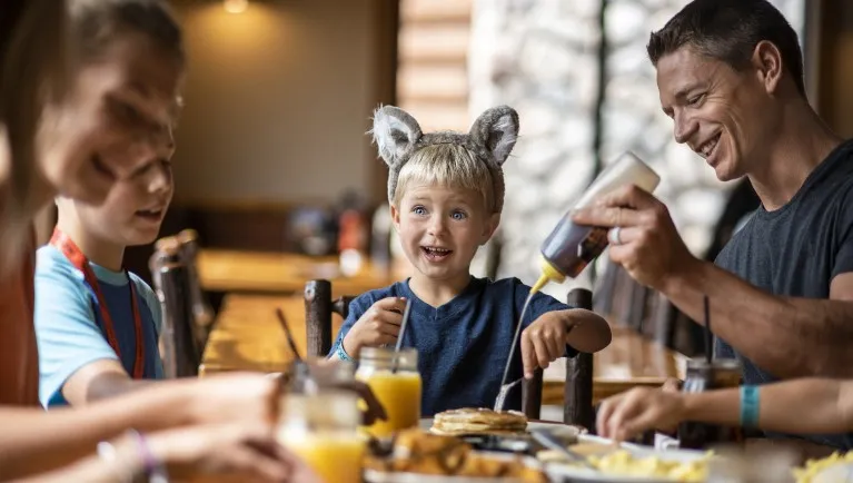 A family enjoying a meal at The Loose Moose Cottage at Great Wolf Lodge indoor water park and resort.