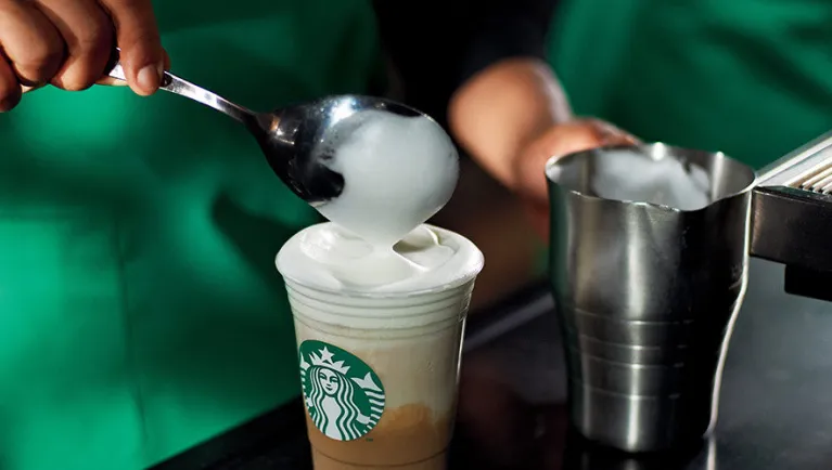 A barista prepares a latte at a Starbucks 