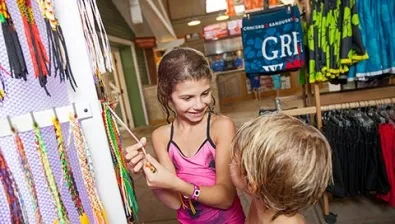 Kids shop for bracelets at Bear Essentials Swim Shop at Great Wolf Lodge indoor water park and resort.