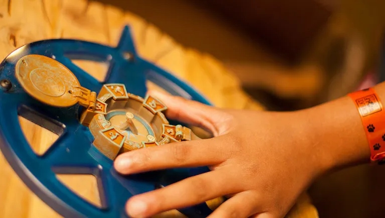 A child holds a compass playing Compass Quest at Great Wolf Lodge indoor water park and resort.