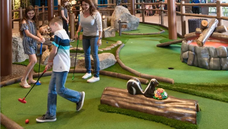 kids along with there mother enjoys a round of mini golf at Great Wolf Lodge indoor water park and resort.