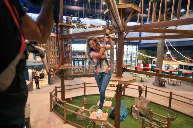 A girl attemptes the Howlers Peak Ropes Course at Great Wolf Lodge indoor water park and resort.