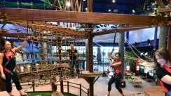 A family walks along the Howlers Peak Ropes Course at Great Wolf Lodge indoor water park and resort.