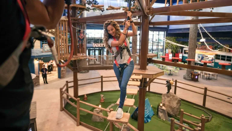 A girl attemptes the Howlers Peak Ropes Course at Great Wolf Lodge indoor water park and resort.