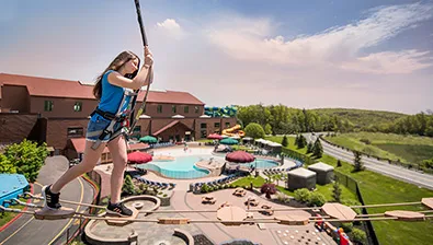 A family walks along the Howlers Peak Ropes Course at Great Wolf Lodge indoor water park and resort.
