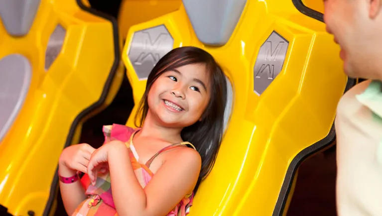 A girl smiles at her dad inside the Howly Wood XD Theater at Great Wolf Lodge indoor water park and resort.