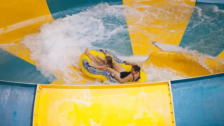 A mother and daughter ride a tube down the Coyote Cannon ride at Great Wolf Lodge indoor water park and resort.