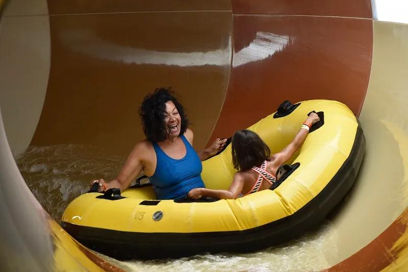 A family rides the Diamond Back Drop water slide