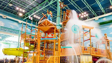 A wide shot of the Talking Stick Treehouse at a Great Wolf Lodge indoor water park.