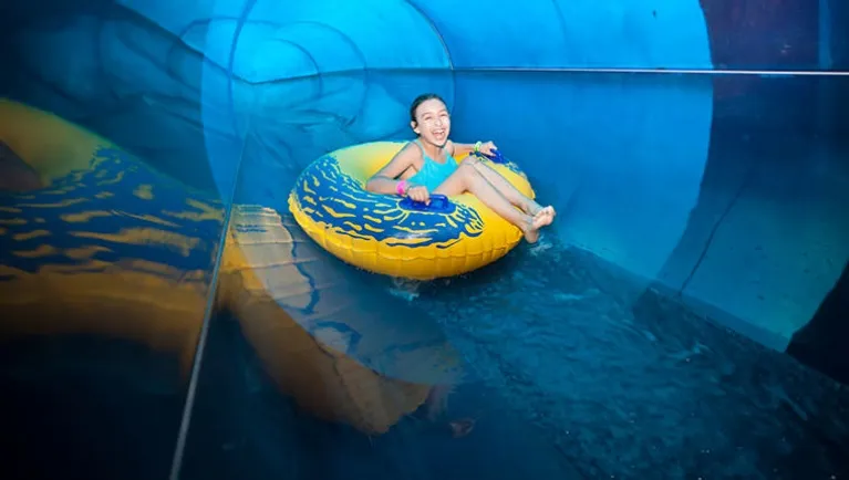 A girl rides a tube down Rapid Racer at Great Wolf Lodge indoor water park and resort.