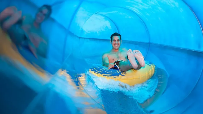 A man rides a tube down Rapid Racer at Great Wolf Lodge indoor water park and resort.