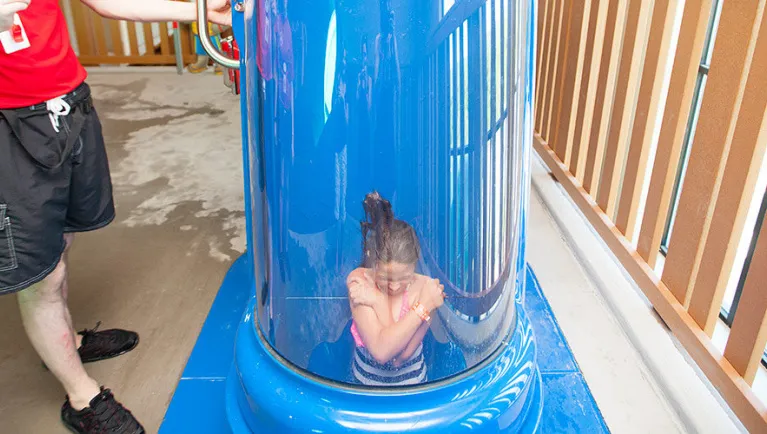 A girl shoots down the Wolf Tail water slide