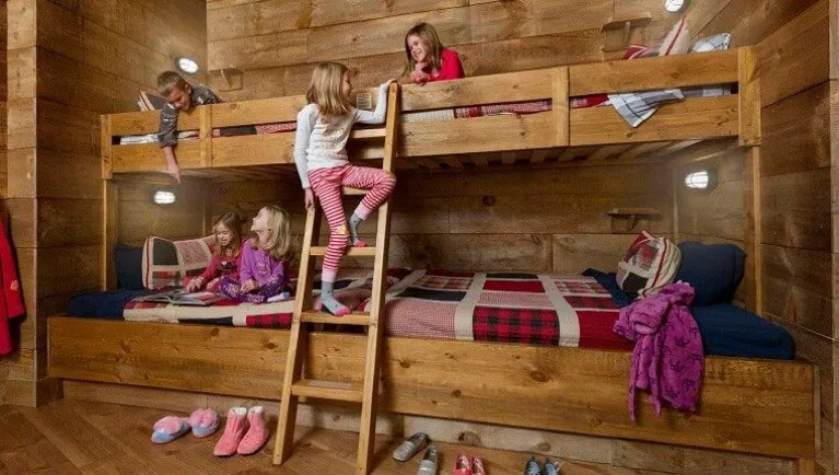 Kids reading books and enjoying their evening in the bunk beds of the Accessible Timber Wolf Cottage